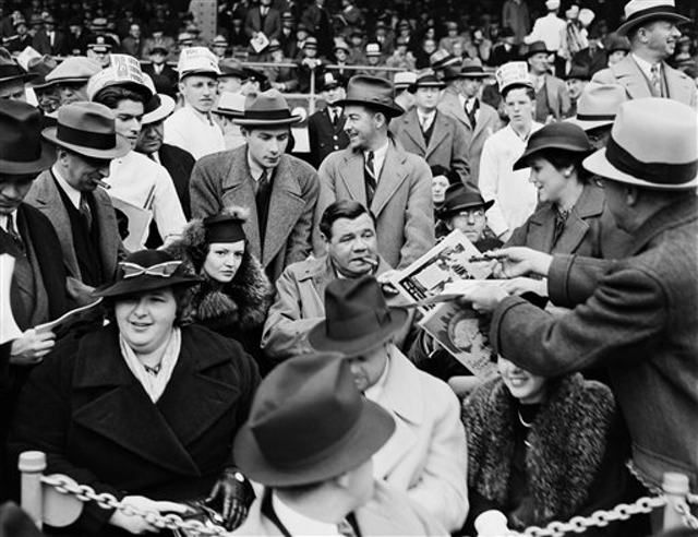 September 30th, 1936â"a man hands a program to baseball legend Babe Ruth, center, as he is joined by his second wife Clare, center left, and singer Kate Smith, front left, in the grandstand during Game 1 of the 1936 World Series at the Polo Grounds in New York."